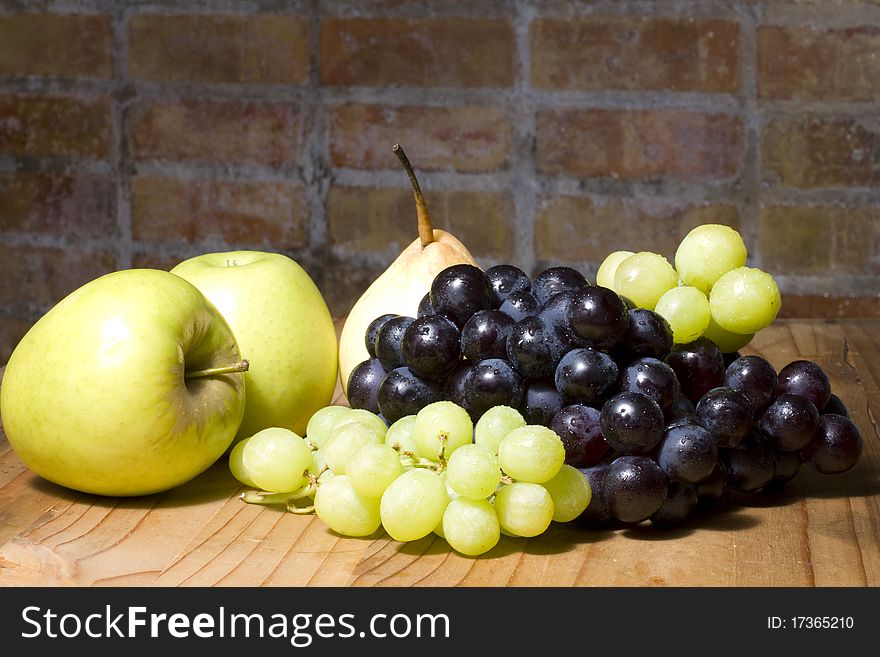 Fresh organic apples, pear and grapes on a wooden table. Fresh organic apples, pear and grapes on a wooden table