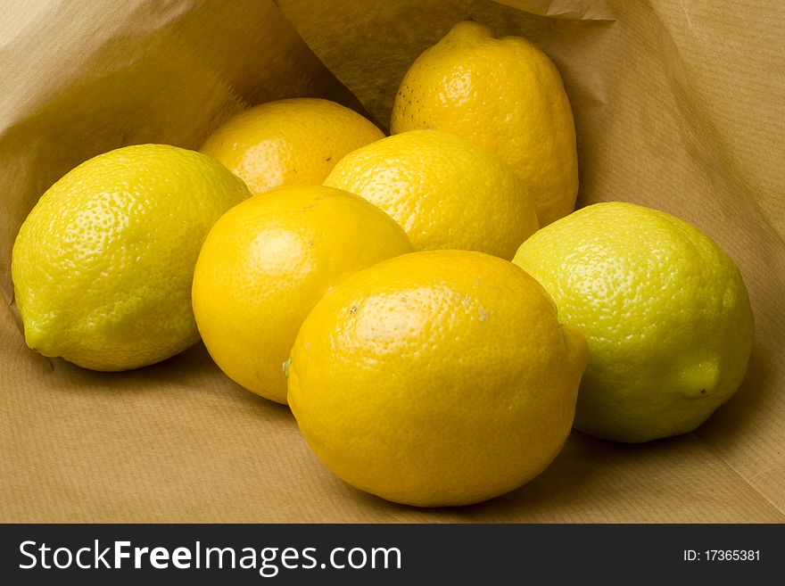 Fresh market lemons and limes in a brown recycled paper shopping bag