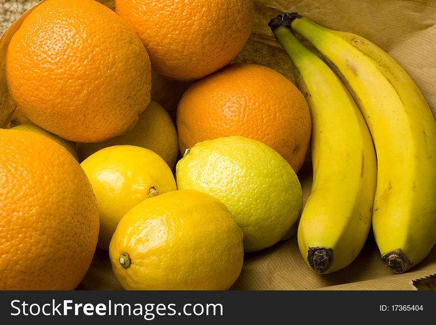 Fresh whole organic oranges, lime and banans on a wooden table surface. Fresh whole organic oranges, lime and banans on a wooden table surface