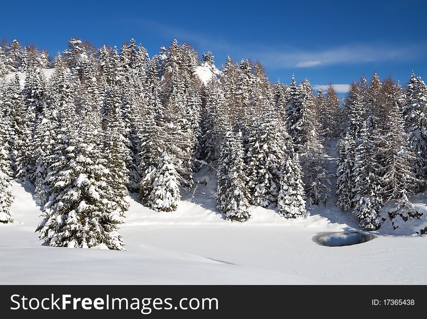 A small icy mountain lake after a frozen winter night. Brixia province, Lombardy region, Italy. A small icy mountain lake after a frozen winter night. Brixia province, Lombardy region, Italy