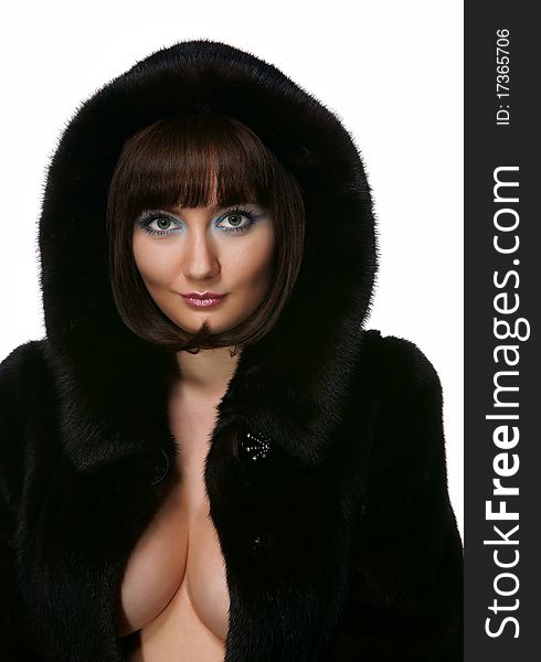 The sexy girl in a fur coat on a white background