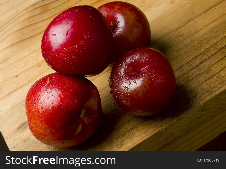 Organic red cherry plums and nectarines on a wooden table