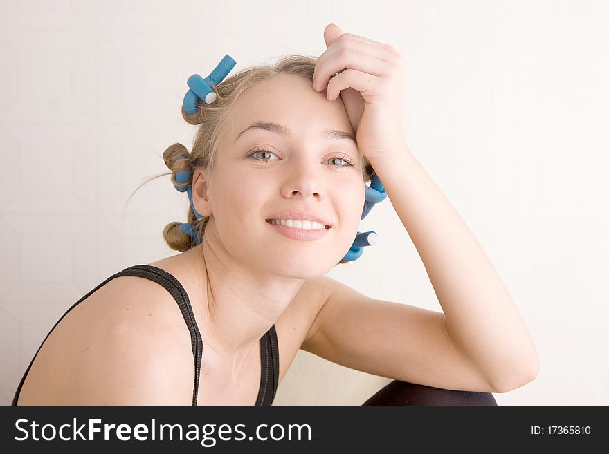 Beautiful young woman curls her hair with curlers. Beautiful young woman curls her hair with curlers.