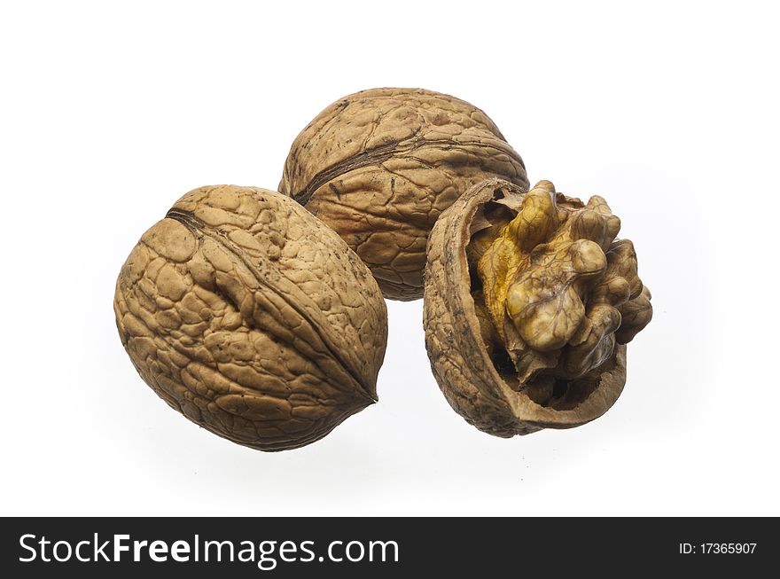 Whole walnuts and cracked walnuts on a white background. Whole walnuts and cracked walnuts on a white background