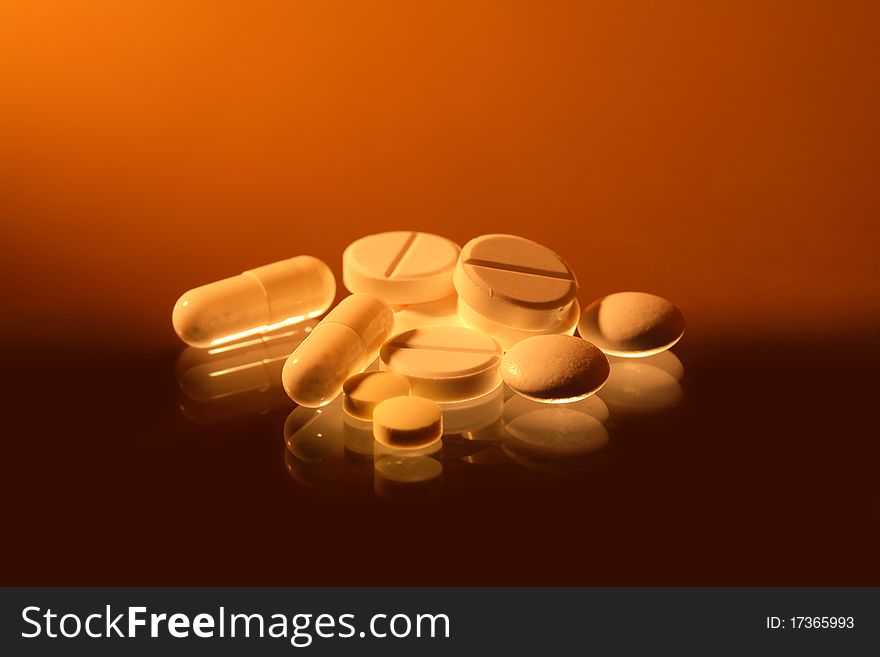 Closeup of various pills with reverberation on sradient background