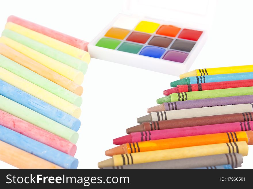 Colored wax pencils, chalk and a watercolor isolated on a on white background with clipping path