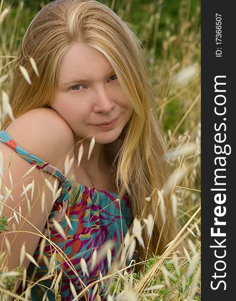 Portrait or a young blond girl in high grass on the meadow. Portrait or a young blond girl in high grass on the meadow