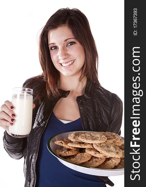 A woman holding on to a plate filled with chocolate chip cookies and in the other had a big glass of milk. She has a huge smile on her face. A woman holding on to a plate filled with chocolate chip cookies and in the other had a big glass of milk. She has a huge smile on her face.