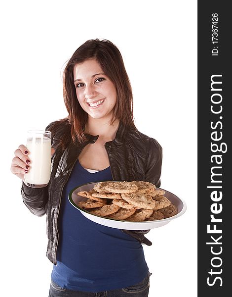 A woman holding on to a plate filled with chocolate chip cookies and in the other had a big glass of milk. She has a huge smile on her face. A woman holding on to a plate filled with chocolate chip cookies and in the other had a big glass of milk. She has a huge smile on her face.