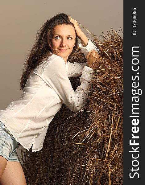 Charming young smiling woman near the haystack