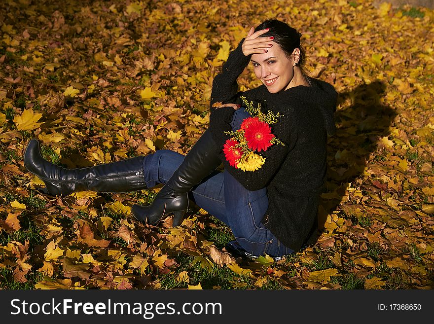 Autumn, girl with flowers on maple leaves. Autumn, girl with flowers on maple leaves