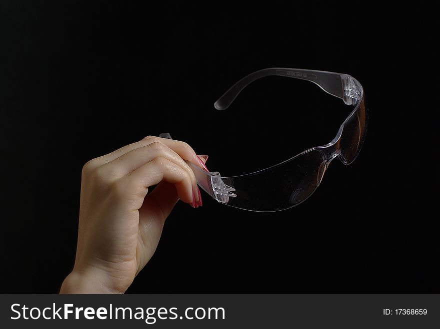 Female hand holding protective goggles. Female hand holding protective goggles