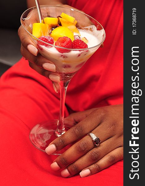 A woman's hand is holding a glass dish with ice-cream. A woman's hand is holding a glass dish with ice-cream.