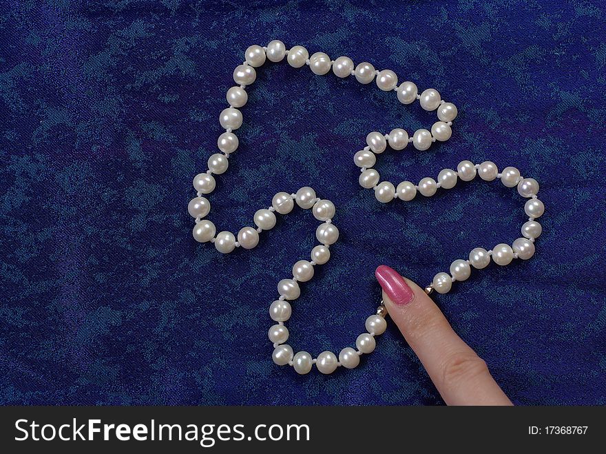 Pearl beads on the blue background. Pearl beads on the blue background