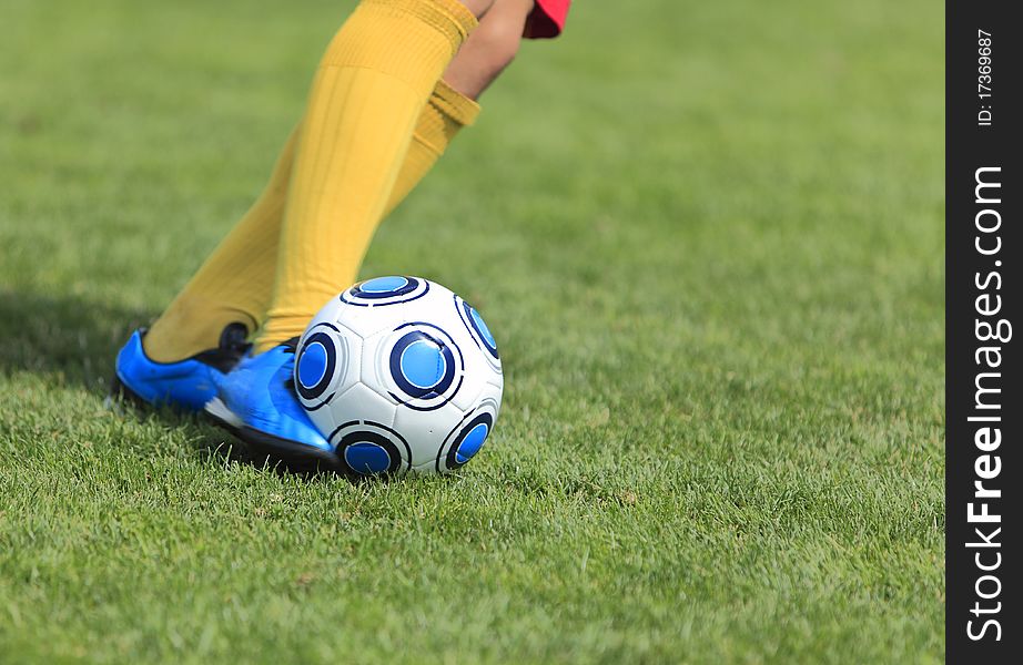 Detail image of a soccer player's leg when is kicking the ball