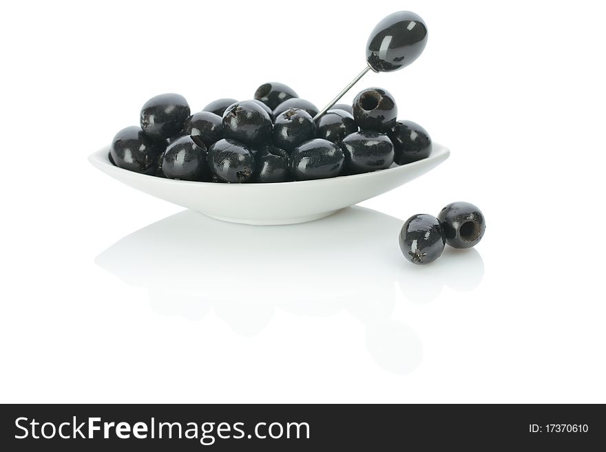 Studio shot black olives on a plate with skewer on white background