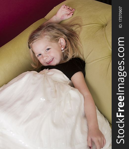 Beautiful young girl posing for the camera laying on couch. Beautiful young girl posing for the camera laying on couch