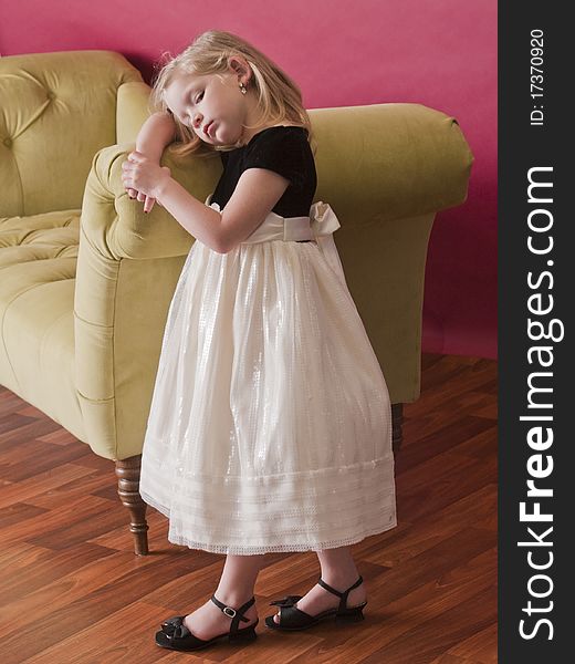 Very sad little girl next to couch. Very sad little girl next to couch