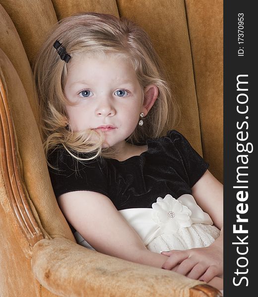 Very sad little girl standing behind couch. Very sad little girl standing behind couch