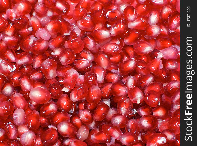 Shiny, juicy berries from the inside of an exotic pomegranate glisten with moisture. Shiny, juicy berries from the inside of an exotic pomegranate glisten with moisture.