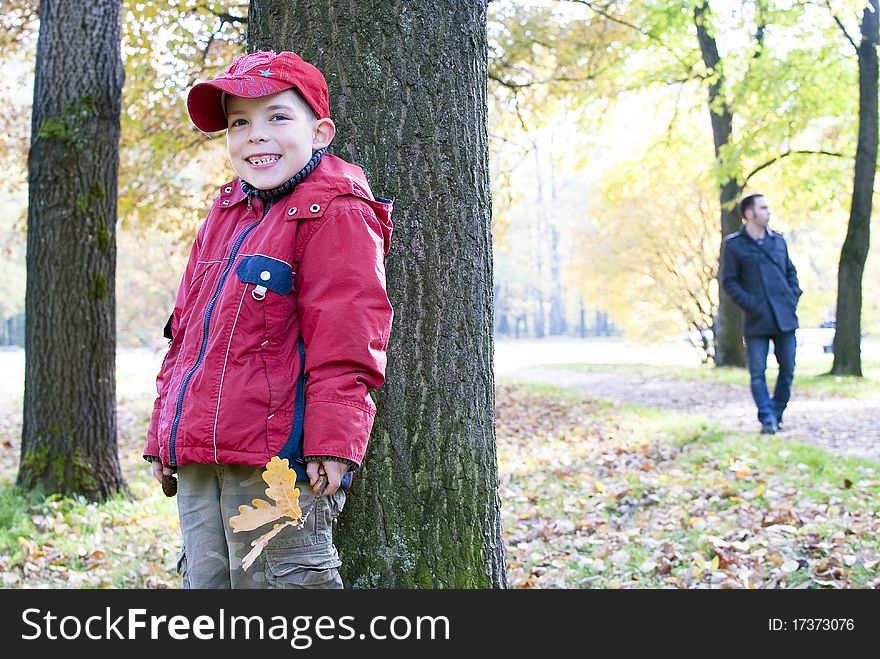 Boy Hiding Behind A Tree From His Dad