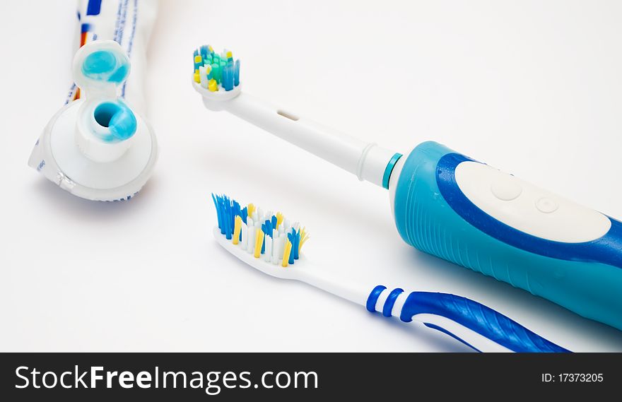 A tooth brush and paste lie on a light background