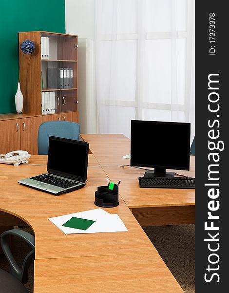 Computer and laptop on a desk at modern office