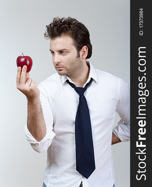 Man in white shirt and tie holding red apple looking - isolated on gray. Man in white shirt and tie holding red apple looking - isolated on gray