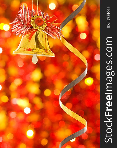 Christmas bell on red blurred background