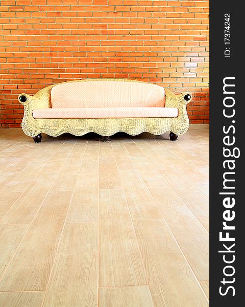 Brick Wall With A Rattan Sofa