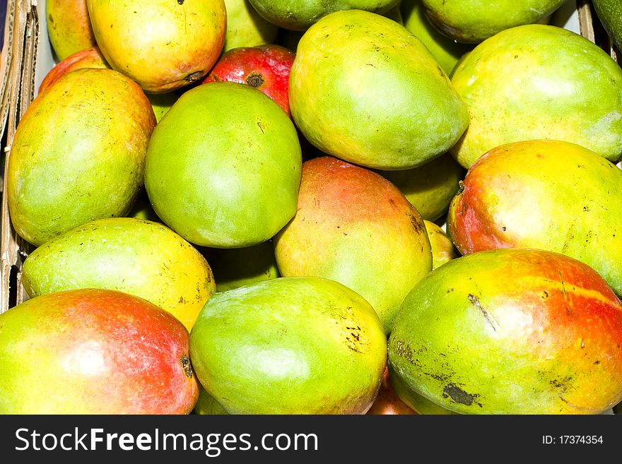 Green, red and yellow mangoes wholesale in a fruit market. Green, red and yellow mangoes wholesale in a fruit market