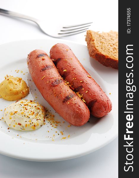 Grilled sausages on a white plate