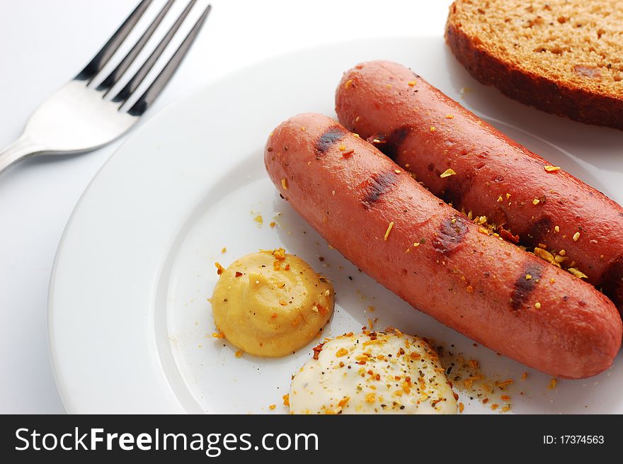 Grilled sausages on a white plate