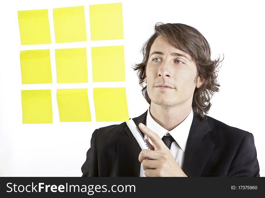 Young businessman looking at postit reminder notes on white background