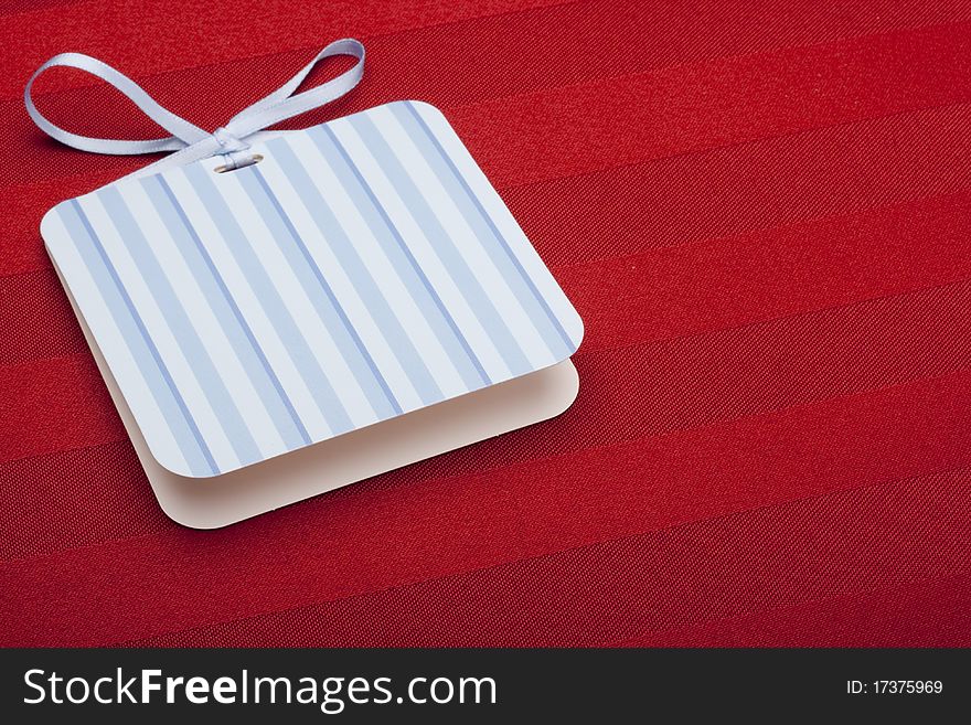 Greeting card with a blue ribbon on a red background.