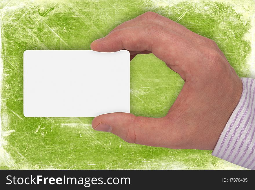 Hand with blank card on green background