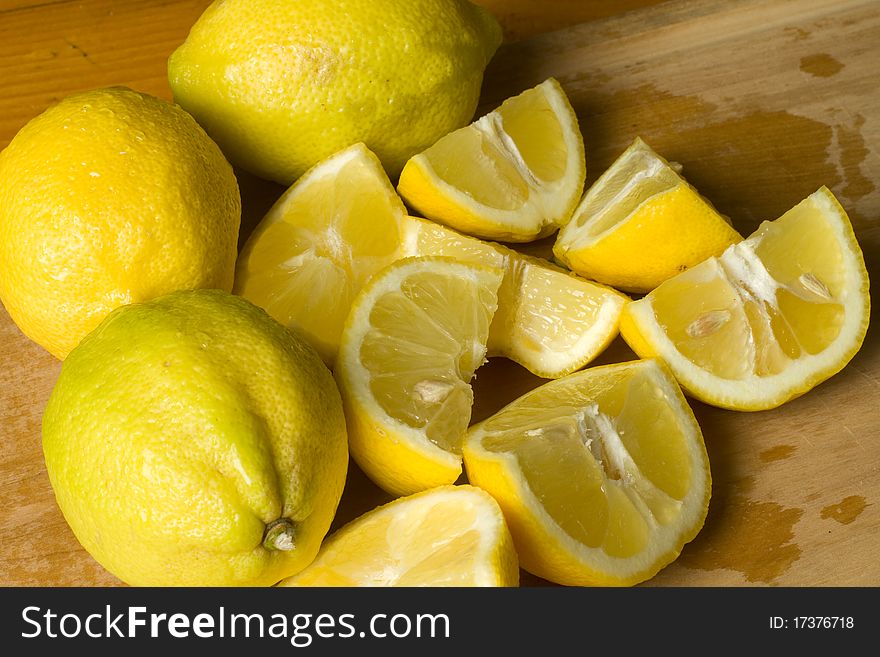 Fresh organic lemon wedges on a wooden cutting board. Fresh organic lemon wedges on a wooden cutting board