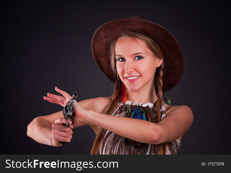 The American Indian girl in a cowboy's hat holds a pistol