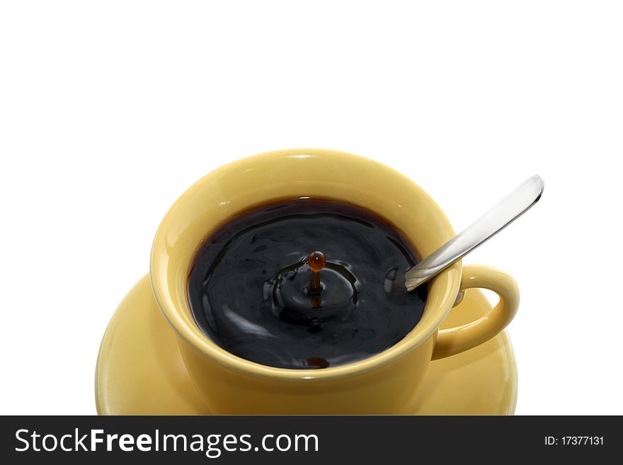 Yellow cup with splashing coffee and spoon isolated on white background. Yellow cup with splashing coffee and spoon isolated on white background