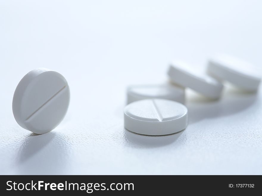 Extreme closeup of few pills on white background with copy space