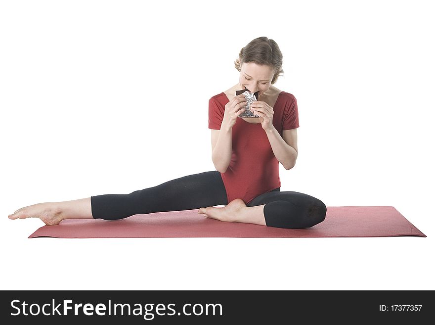 Young woman in sports clothes eating chocolate. Young woman in sports clothes eating chocolate