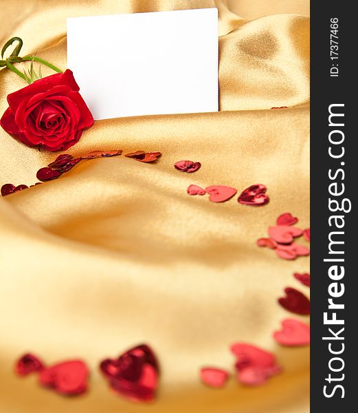 Red rose and white blank greeting card on golden satin. Red rose and white blank greeting card on golden satin