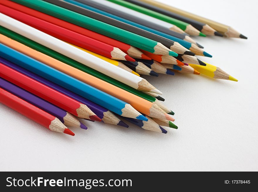 A number of colored pencils on white background
