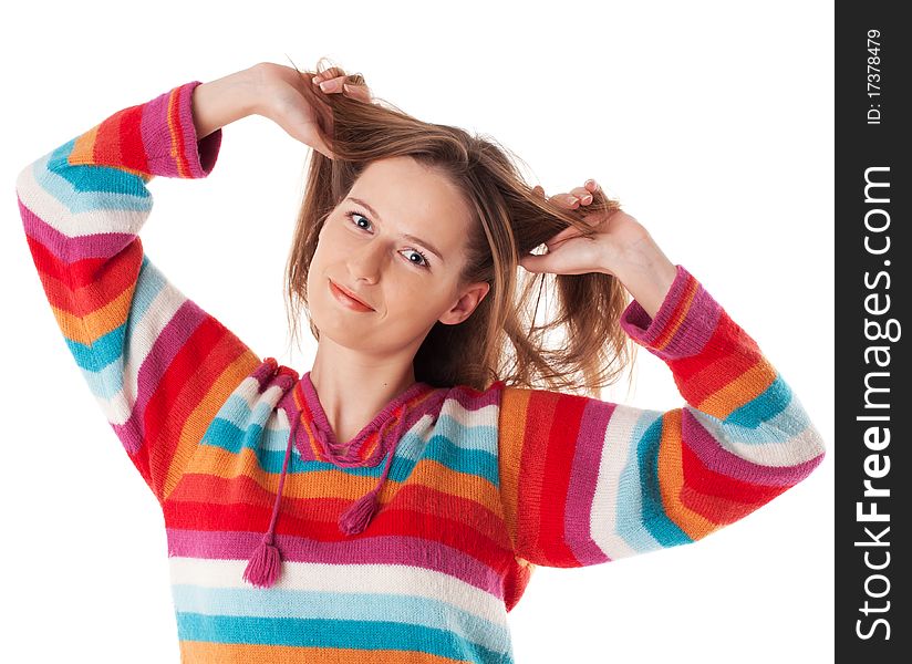Young happy woman standing in colorfiul sweater and smiling grabs her hair. Young happy woman standing in colorfiul sweater and smiling grabs her hair