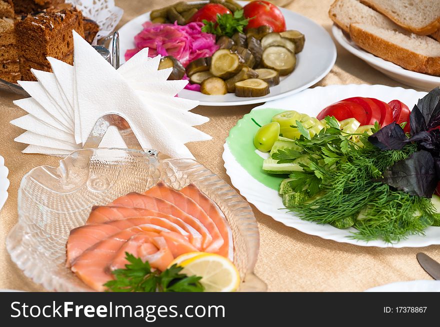 Tableware, paper napkins, salt, spices and appetizer on a table. Tableware, paper napkins, salt, spices and appetizer on a table.