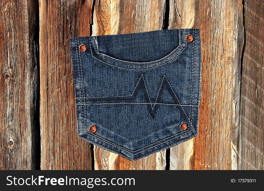 Jeans pocket on a wooden texture