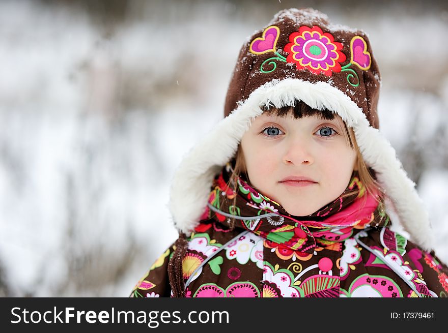 Adorable small girl in colorful winter clothes plays with snow in strong snowfall. Adorable small girl in colorful winter clothes plays with snow in strong snowfall