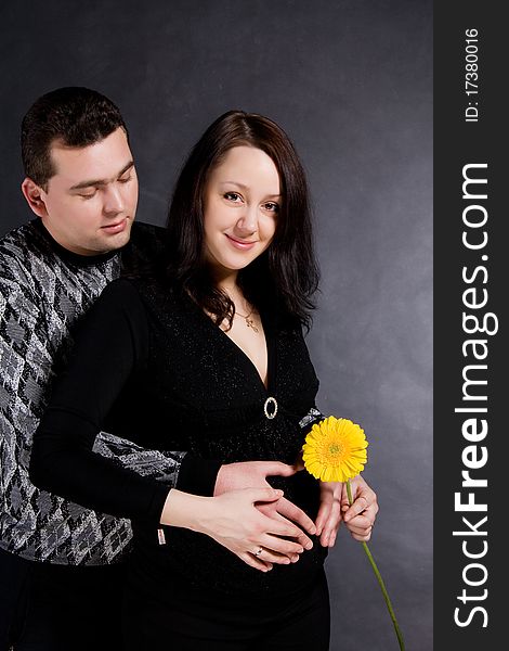 Pregnant couple posing, isolated on dark background. Pregnant couple posing, isolated on dark background