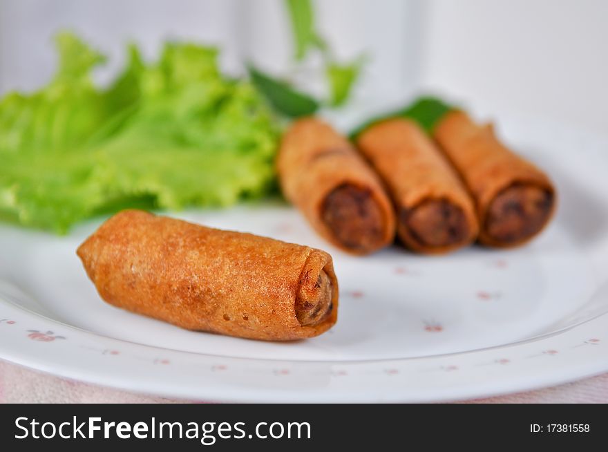 Fried spring rolls served with vegetables.