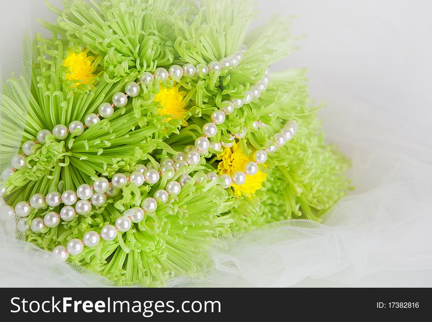 Necklace of pearls and bouquet of chrysanthemums